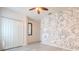Spacious bedroom featuring artistic wall mural, wood-look floors and ceiling fan at 1218 Halapa Way, Trinity, FL 34655