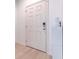 A secure white front door and adjacent storage on the plank flooring at 1218 Halapa Way, Trinity, FL 34655