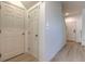 Hallway with three doors, light walls and modern wood-look floors at 1218 Halapa Way, Trinity, FL 34655