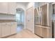 Stainless steel refrigerator complements the white cabinets and granite counters in this kitchen at 1218 Halapa Way, Trinity, FL 34655