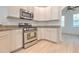 Bright kitchen features stainless steel appliances, granite counters, and white cabinets at 1218 Halapa Way, Trinity, FL 34655