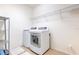 Functional laundry room with modern washer and dryer and wire shelving for storage at 1218 Halapa Way, Trinity, FL 34655