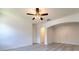 Well-lit living room boasts light-colored wood floors, arched doorways, and a modern ceiling fan with light fixture at 1218 Halapa Way, Trinity, FL 34655