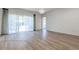 Large living room with modern wood-look flooring and sliding glass doors at 1218 Halapa Way, Trinity, FL 34655