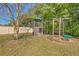 Backyard playground featuring climbing wall, swings, covered tower and monkey bars provides outdoor entertainment at 1218 Halapa Way, Trinity, FL 34655