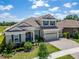 Aerial view of a beautiful two-story home with a tile roof, three-car garage, and lush landscaping at 14239 Swiss Bridge Dr, Riverview, FL 33579