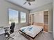 Cozy bedroom featuring a murphy bed with side cabinets, a ceiling fan, and natural light from two windows at 14239 Swiss Bridge Dr, Riverview, FL 33579