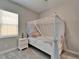 Bright bedroom showcasing a canopy bed, bedside table, and natural light from the window at 14239 Swiss Bridge Dr, Riverview, FL 33579