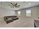 Bright bonus room features plush carpeting, a ceiling fan, and a comfortable sectional sofa at 14239 Swiss Bridge Dr, Riverview, FL 33579