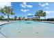 Community pool with shallow wading area and umbrella with palm trees at 14239 Swiss Bridge Dr, Riverview, FL 33579