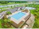 Aerial view of the community pool, clubhouse, and surrounding landscape at 14239 Swiss Bridge Dr, Riverview, FL 33579