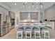 Open-concept kitchen with gray cabinets, stainless appliances, island, and stools, with an archway to a buffet area at 14239 Swiss Bridge Dr, Riverview, FL 33579