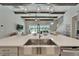 Open concept kitchen island with stainless steel sink, quartz counters, and pendant lighting overlooking the living area at 14239 Swiss Bridge Dr, Riverview, FL 33579
