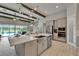 Open concept kitchen featuring stainless appliances, island with sink, pendant lighting, and wooden beams overhead at 14239 Swiss Bridge Dr, Riverview, FL 33579