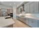 Modern kitchen with sleek gray cabinetry, stainless steel appliances, tile backsplash, and light wood flooring at 14239 Swiss Bridge Dr, Riverview, FL 33579