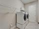 Bright laundry room with front loading washer/dryer and shelving unit at 14239 Swiss Bridge Dr, Riverview, FL 33579