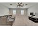Spacious living room featuring a large sectional sofa, plush carpet, and modern entertainment center at 14239 Swiss Bridge Dr, Riverview, FL 33579