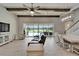 Open living space with exposed beams, fan, view of pool and access to a staircase at 14239 Swiss Bridge Dr, Riverview, FL 33579