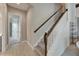 Hallway featuring tiled floors and stairs with wood banisters, leading to the upper level of the home at 14239 Swiss Bridge Dr, Riverview, FL 33579