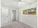 Bright bedroom features a ceiling fan, window, and closet space at 145 Avon Dr, Safety Harbor, FL 34695