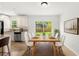 Sunlit dining area with a wooden table set for six, complemented by views of the green backyard, perfect for gatherings at 145 Avon Dr, Safety Harbor, FL 34695