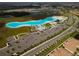 Aerial view of the community lagoon, water park, and surrounding residential area and amenities at 16927 April Plush Dr, Wimauma, FL 33598