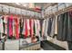 A well organized closet with clothing hung on rods and bins on shelves above at 16927 April Plush Dr, Wimauma, FL 33598