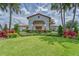 Exterior view of clubhouse featuring lush landscaping, manicured lawn, and a grand entrance at 16927 April Plush Dr, Wimauma, FL 33598