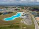 An aerial view of a neighborhood with a Personal-made lagoon, and parking. There is green space as well at 16927 April Plush Dr, Wimauma, FL 33598