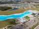 Aerial view of the lagoon that features clear blue water. It is surrounded by parking and green space at 16927 April Plush Dr, Wimauma, FL 33598