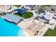 Aerial of beach club and sand, featuring chair and covered sitting areas, all in front of turquoise lagoon at 16927 April Plush Dr, Wimauma, FL 33598
