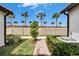 Landscaped yard with sidewalk and a view of palm trees lining the fence at 16927 April Plush Dr, Wimauma, FL 33598