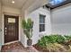 Inviting front entrance with a decorative welcome mat, plants, and a brick walkway at 16927 April Plush Dr, Wimauma, FL 33598
