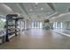 Bright gym with exercise equipment, mirrored walls, and doors leading to outdoor spaces at 16927 April Plush Dr, Wimauma, FL 33598