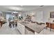 The kitchen island features a granite countertop, seating, and a sink, flowing into living spaces at 16927 April Plush Dr, Wimauma, FL 33598