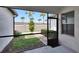 Screened in lanai looking out to a grass backyard with palm trees and a walking path at 16927 April Plush Dr, Wimauma, FL 33598