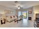 Bright living room with neutral tones, tile flooring, and sliding glass doors that lead to the outside patio at 16927 April Plush Dr, Wimauma, FL 33598