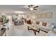 Open-concept living room flows into the dining area and kitchen featuring modern lighting and neutral tones at 16927 April Plush Dr, Wimauma, FL 33598