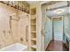 Bathroom with walk in shower featuring a bathtub, shelving and acces to the closet at 2403 S Ardson Pl # 902B, Tampa, FL 33629