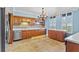 Spacious kitchen with stainless dishwasher and appliances, wood cabinets, and tiled backsplash at 2403 S Ardson Pl # 902B, Tampa, FL 33629