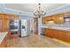 Kitchen features stainless appliances, tile floor, wood cabinets and backsplash, and modern lighting at 2403 S Ardson Pl # 902B, Tampa, FL 33629