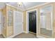 Hallway featuring an entry door, a closet with white slatted doors and a mirrored wall at 2403 S Ardson Pl # 902B, Tampa, FL 33629