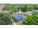 Blue house, a gray roof, and a covered porch surrounded by mature trees in a quiet neighborhood at 2408 Linsey St, Tampa, FL 33605
