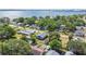 Aerial view of blue house in neighborhood with water view in the distance and lush surrounding greenery at 2408 Linsey St, Tampa, FL 33605