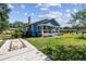 Quaint blue bungalow with a brick chimney, cozy porch, and well-maintained lawn on a sunny day at 2408 Linsey St, Tampa, FL 33605