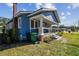 Quaint blue bungalow with a cozy porch, manicured lawn, and architectural details on a sunny day at 2408 Linsey St, Tampa, FL 33605