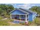 Charming front exterior of a blue house with a cozy covered porch and well-maintained landscaping at 2408 Linsey St, Tampa, FL 33605