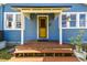 Charming blue house with a yellow door and a cozy covered front porch at 2408 Linsey St, Tampa, FL 33605