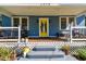 Inviting front porch featuring a vibrant yellow door, seating, and charming architectural details at 2408 Linsey St, Tampa, FL 33605