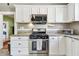 Well-lit kitchen features granite countertops, stainless steel appliances, and white cabinets, offering a functional cooking area at 2408 Linsey St, Tampa, FL 33605